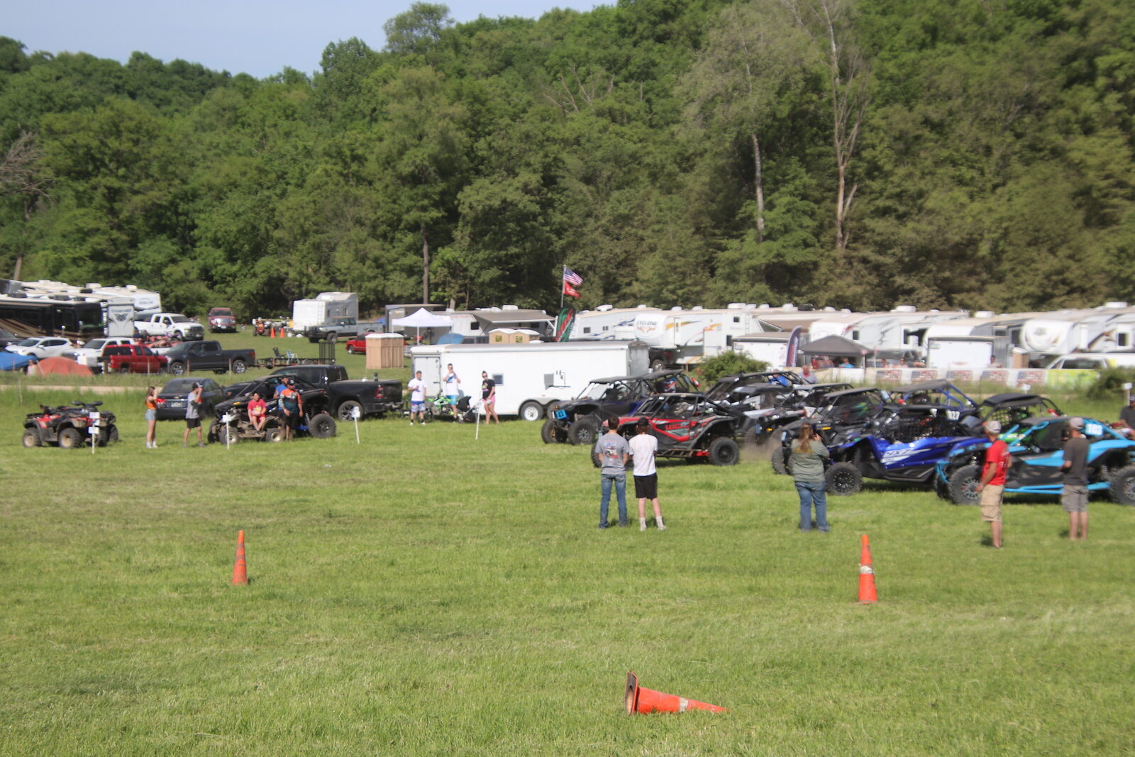 The paddock area with trucks, trailers, and UTVs before a race